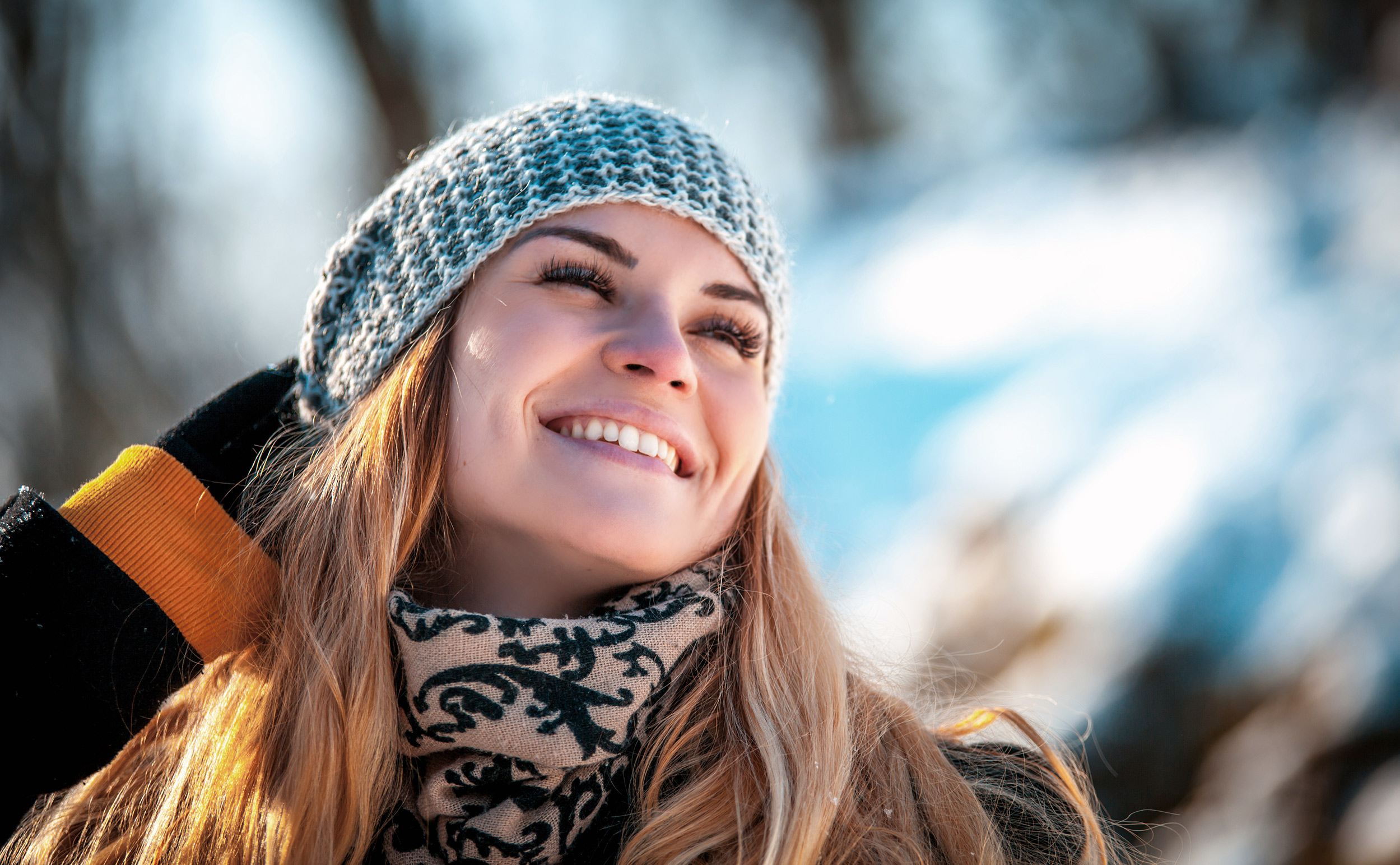 nainen hymyilee ulkona talvella harmaa pipo päässä